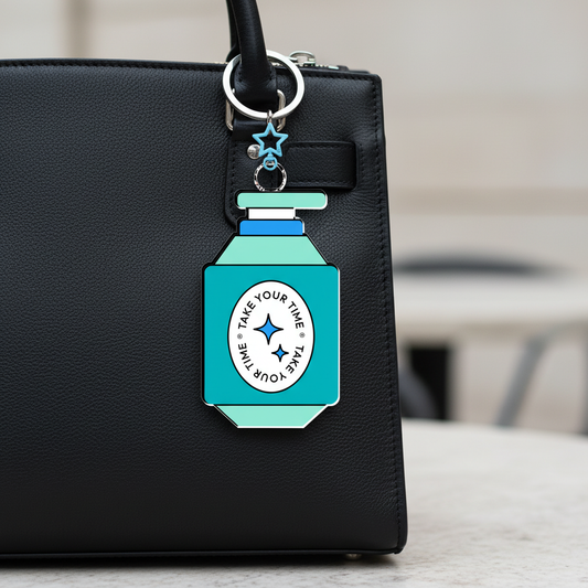 Black handbag with a turquoise keychain attached, featuring a star design.